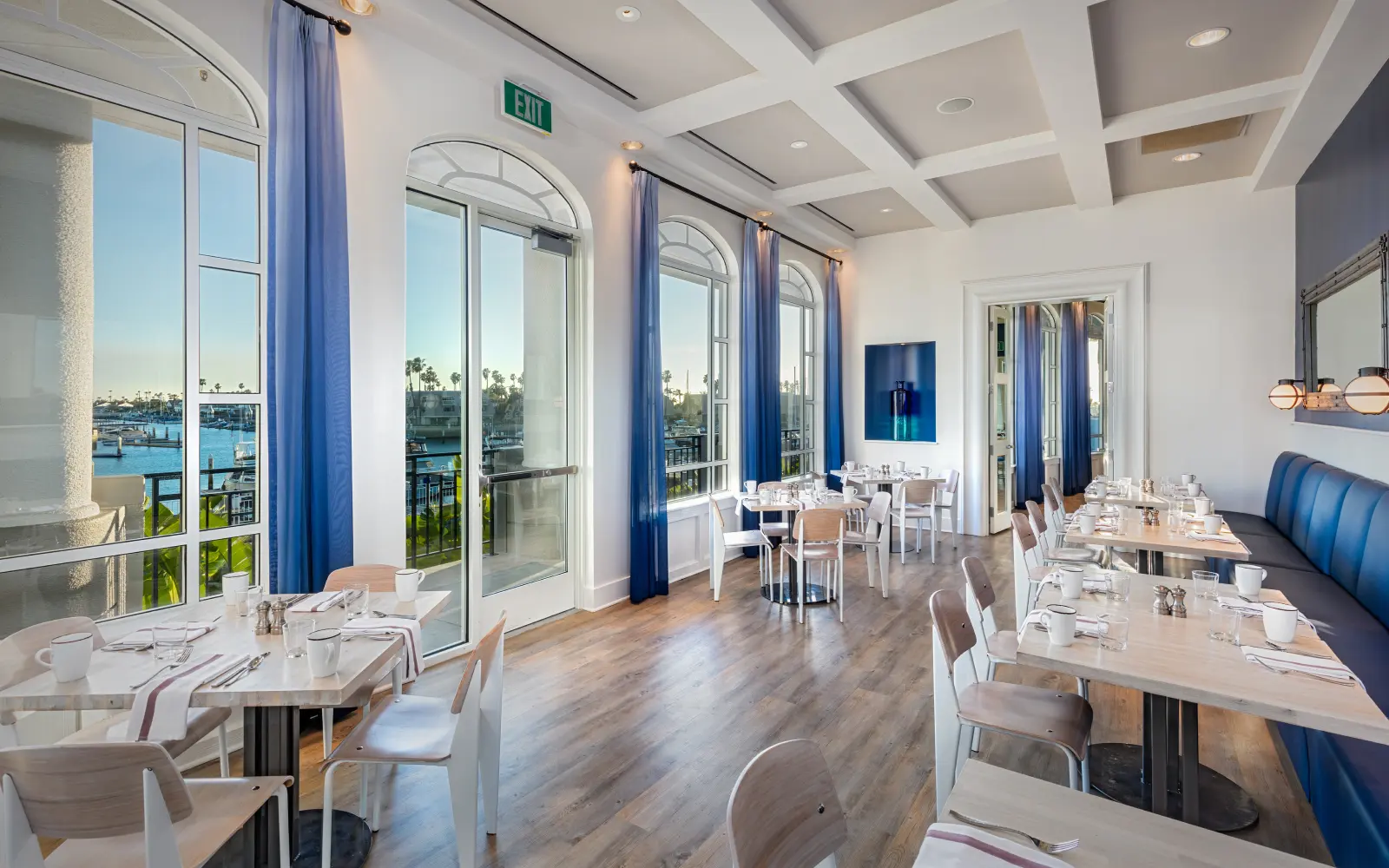 A waterfront session room with floor-to-ceiling glass facing the bay.